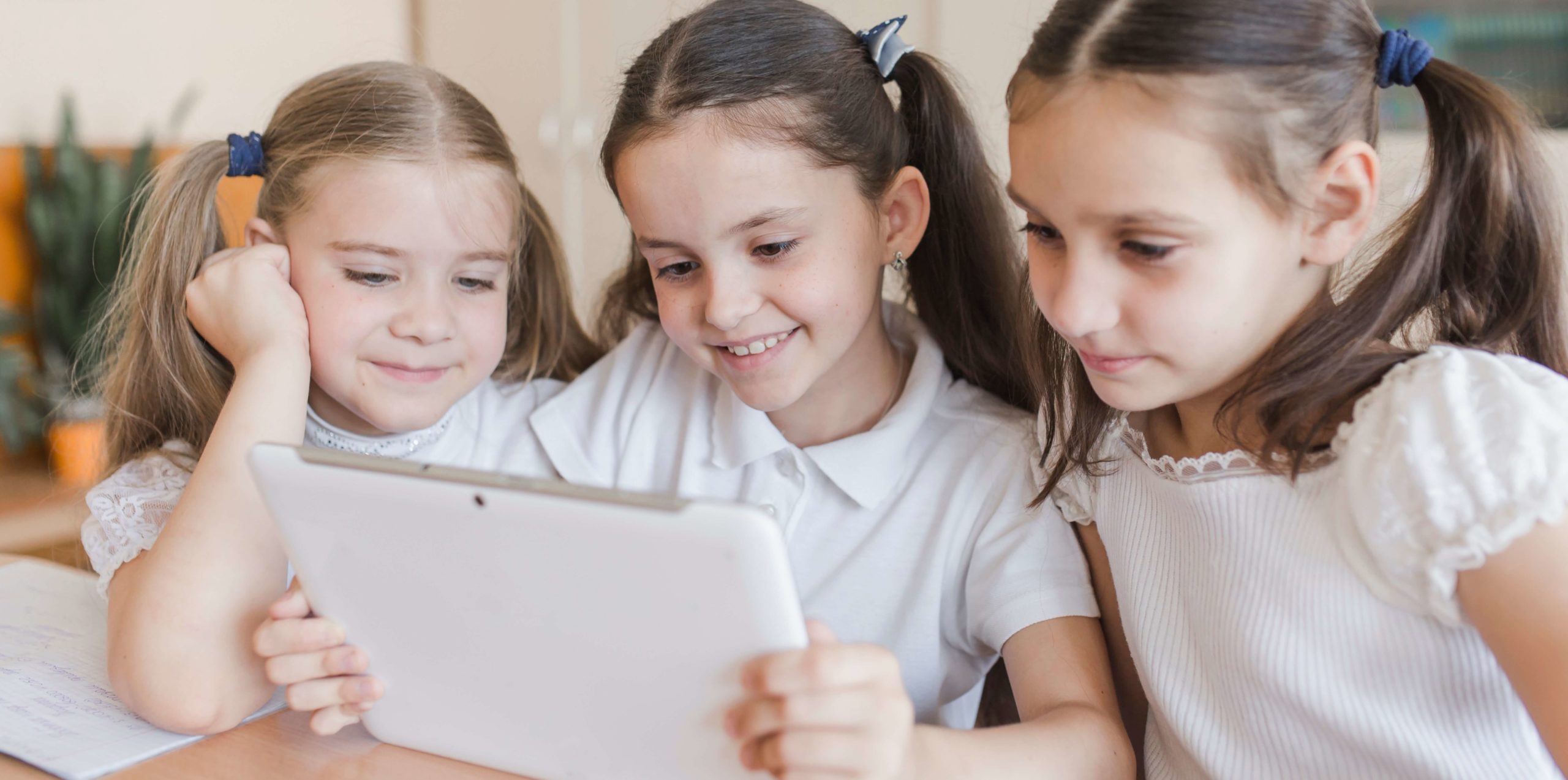 La gamificación en las Apps de Educación. Tres niñas interactuando con una tablet en el colegio.